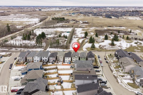 Aerial view of the property and its surrounding neighborhood, featuring residential homes, paved roads, and open land - 5164 Lark Crescent Nw, Edmonton, AB - Outdoor With View