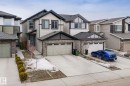 The property features a two-story exterior with light-colored siding, dark trim, and stone accents - 5164 Lark Crescent Nw, Edmonton, AB  - Outdoor With Facade 