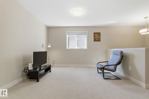 Living area featuring light-colored carpet, a window with blinds, and neutral-toned walls - 3235 Abbott Crescent, Edmonton, AB - Indoor Photo Showing Other Room