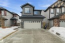 The property features a concrete driveway and an attached garage with a light-colored door - 3235 Abbott Crescent, Edmonton, AB  - Outdoor With Facade 