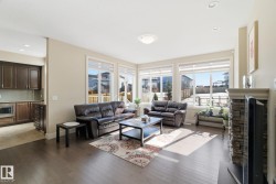 The living area features hardwood floors and large windows providing natural light - 