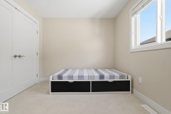 Room with light-colored walls and carpeted flooring, featuring a window with white trim - 