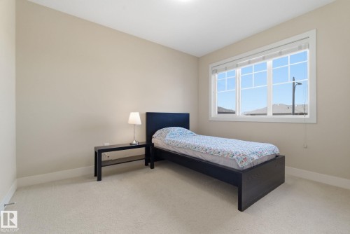 A bright room featuring a window with white trim, light-colored walls, and carpet flooring - 3235 Abbott Crescent, Edmonton, AB - Indoor Photo Showing Bedroom