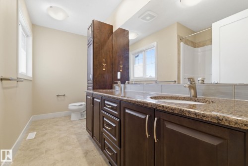 Bathroom featuring a dark wood vanity with a granite countertop and a chrome faucet - 3235 Abbott Crescent, Edmonton, AB - Indoor Photo Showing Bathroom