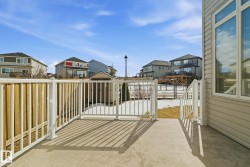 The property features a concrete patio with white railings, offering views of the surrounding neighborhood and a shed - 