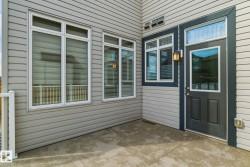 The property features a patio with a concrete surface, a door with a window inset, and several windows with blinds - 