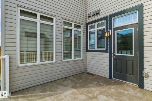 The property features a patio with a concrete surface, a door with a window inset, and several windows with blinds - 3235 Abbott Crescent, Edmonton, AB - Outdoor With Deck Patio Veranda