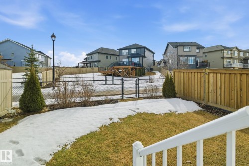 The property features a spacious yard with a lawn and a black chain link fence - 3235 Abbott Crescent, Edmonton, AB - Outdoor