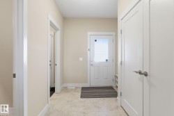 Entryway featuring light-colored walls, white trim, and a white door with a window panel - 