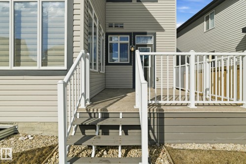This property features a deck with white railings and exterior steps, providing access to the yard - 3235 Abbott Crescent, Edmonton, AB - Outdoor With Exterior