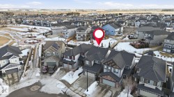 Aerial view of the property and its surrounding neighborhood, featuring residential homes with visible driveways and roofs - 