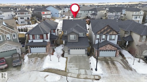 The property features a multi-story design with a dark gray roof and siding, complemented by a front-facing garage with a light gray door - 3235 Abbott Crescent, Edmonton, AB -  With Facade