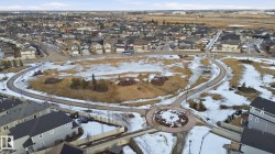 Aerial view showcasing the residential area with various properties, a public pathway, and open green spaces - 