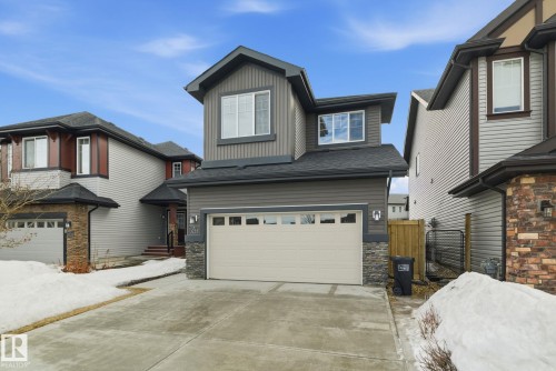 The property features a concrete driveway leading to an attached double garage - 3235 Abbott Crescent, Edmonton, AB - Outdoor With Facade