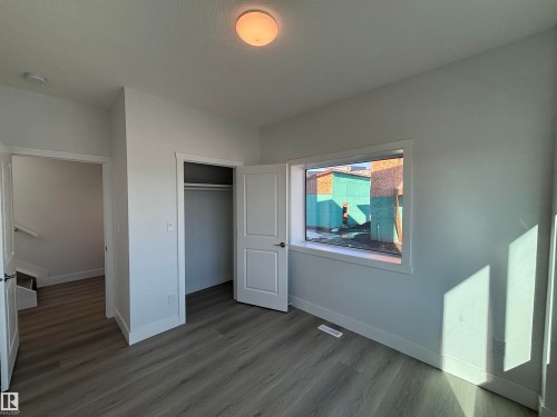 This room features a window with white trim, a closet with a white door, and light-colored plank flooring - 2740 Blatchford Road, Edmonton, AB - Indoor Photo Showing Other Room