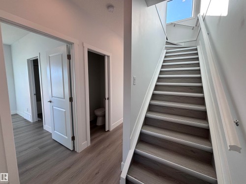 Staircase with light wood-style flooring and white risers, complemented by a white handrail and white walls - 2740 Blatchford Road, Edmonton, AB - Indoor Photo Showing Other Room