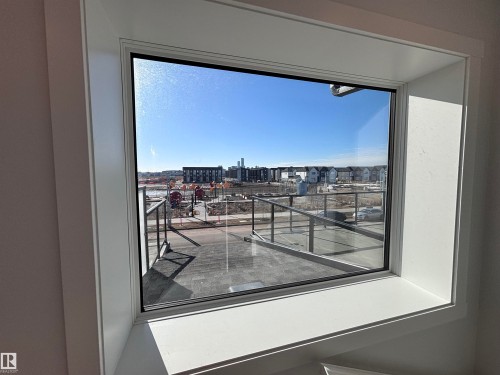 The property features a window providing views of the surrounding neighborhood and a clear blue sky - 2740 Blatchford Road, Edmonton, AB - Indoor Photo Showing Other Room