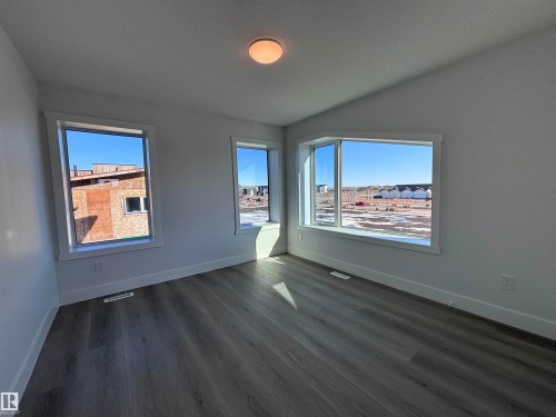 This room features light-toned walls and dark-toned flooring - 2740 Blatchford Road, Edmonton, AB - Indoor Photo Showing Other Room