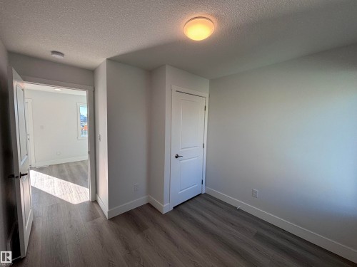 Room featuring light-colored walls, recessed lighting, and wood-look flooring - 2740 Blatchford Road, Edmonton, AB - Indoor Photo Showing Other Room