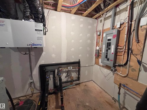 The property features exposed wooden ceiling joists, an electrical panel, and a "Lifebreath" brand ventilation system - 2740 Blatchford Road, Edmonton, AB - Indoor Photo Showing Basement