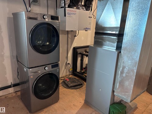 Dedicated laundry area featuring a stacked washer and dryer, adjacent to mechanical equipment - 2740 Blatchford Road, Edmonton, AB - Indoor Photo Showing Laundry Room