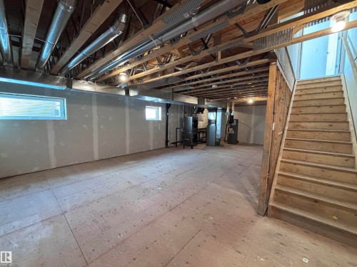 The property features an unfinished basement with exposed wooden beams, ductwork, and utility systems, offering potential for customization - 2740 Blatchford Road, Edmonton, AB - Indoor Photo Showing Basement