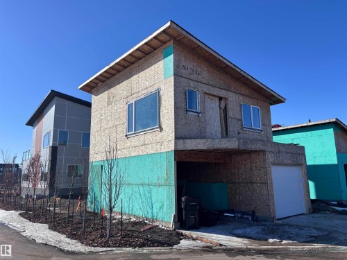 Property under construction with visible framing and a sloped roofline, featuring an integrated garage space and several windows - 2740 Blatchford Road, Edmonton, AB - Outdoor