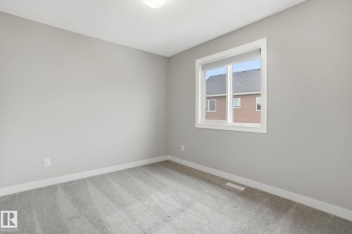 This room features light grey walls and light grey carpet - 1607 202 Street, Edmonton, AB - Indoor Photo Showing Other Room