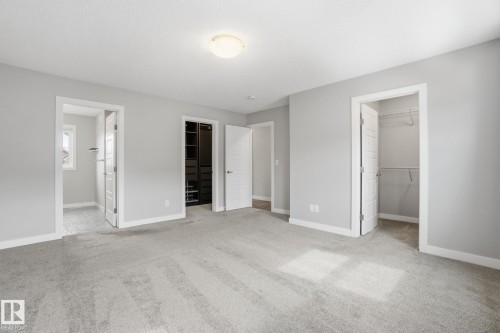 This room features light grey walls and light-colored carpet, creating a bright and airy atmosphere - 1607 202 Street, Edmonton, AB - Indoor