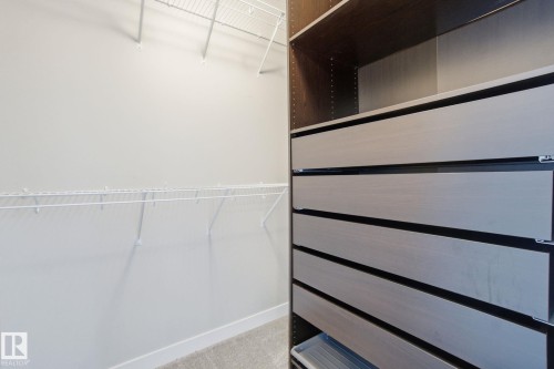 Spacious closet with built-in dark wood shelving and drawers, complemented by white wire shelving - 1607 202 Street, Edmonton, AB - Indoor With Storage