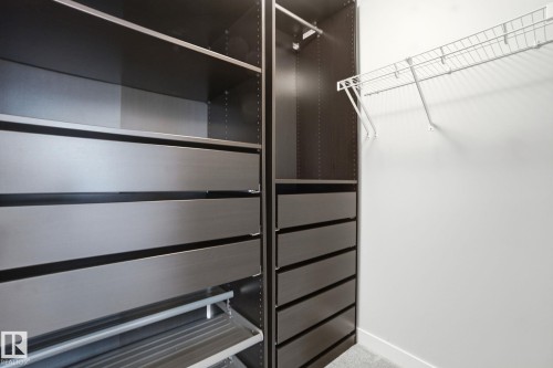 The property features a closet with built-in dark cabinetry, drawers, and shelving, providing ample storage - 1607 202 Street, Edmonton, AB - Indoor
