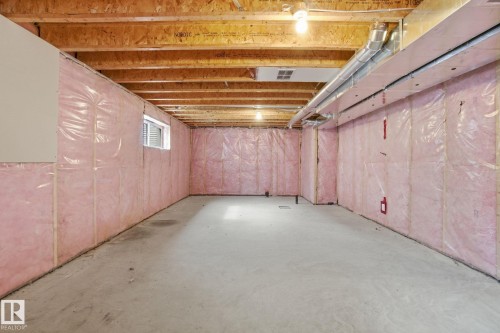Spacious unfinished basement with exposed wooden beams, concrete flooring, and insulated walls - 1607 202 Street, Edmonton, AB - Indoor Photo Showing Basement