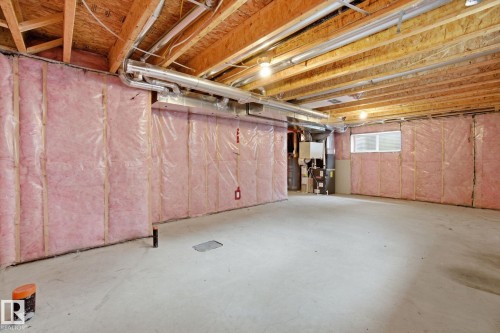 The property features a spacious, unfinished basement with exposed wooden joists and insulated walls - 1607 202 Street, Edmonton, AB - Indoor Photo Showing Basement
