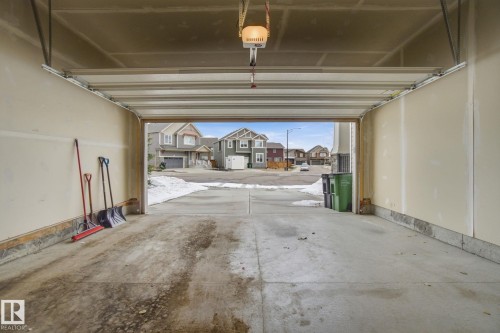 Spacious garage with concrete flooring and an automatic garage door opener - 1607 202 Street, Edmonton, AB - Indoor Photo Showing Garage