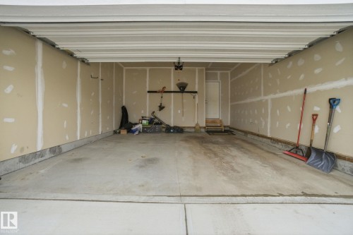 The property includes an attached garage with a concrete floor and a white overhead garage door - 1607 202 Street, Edmonton, AB - Indoor Photo Showing Garage