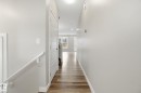 Hallway featuring light-colored walls, wood-style flooring, and white trim - 1607 202 Street, Edmonton, AB  - Indoor Photo Showing Other Room 