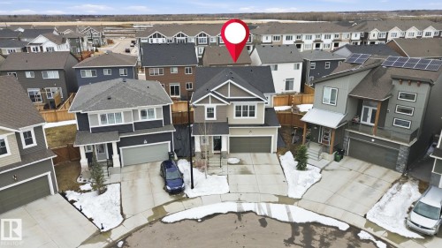 The property features a two-story exterior with an attached garage, a driveway, and a front yard with some landscaping - 1607 202 Street, Edmonton, AB -  With Facade