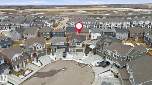 Aerial view of the property and its surrounding neighborhood, showcasing a residential street with detached homes and townhouses - 1607 202 Street, Edmonton, AB - 