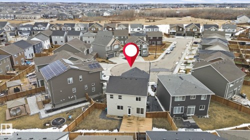 Aerial view of the property and its surrounding neighborhood, featuring a residential street and a large undeveloped area in the background - 1607 202 Street, Edmonton, AB - Outdoor With View