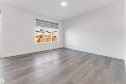 This room features light-colored walls, recessed lighting, and a window with blinds - 