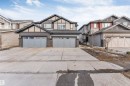 The property features a concrete driveway and two attached garages with light grey doors, offering ample parking - 1663 Cavanagh Boulevard Sw, Edmonton, AB  - Outdoor With Facade 