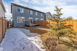 The property features a private yard with a wooden fence and a mature tree, along with a wooden deck accessible via sliding glass doors - 