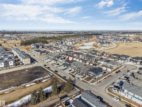 Aerial view of the surrounding neighbourhood, featuring residential streets, houses, and undeveloped land - 1663 Cavanagh Boulevard Sw, Edmonton, AB - Outdoor With View