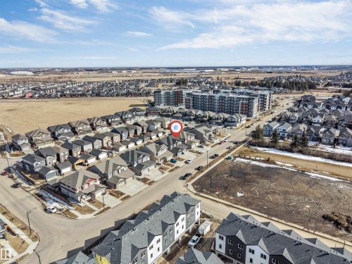 An aerial view of the property's neighborhood, showcasing residential streets, detached homes, and a larger apartment building in the surrounding area - 1663 Cavanagh Boulevard Sw, Edmonton, AB - Outdoor With View