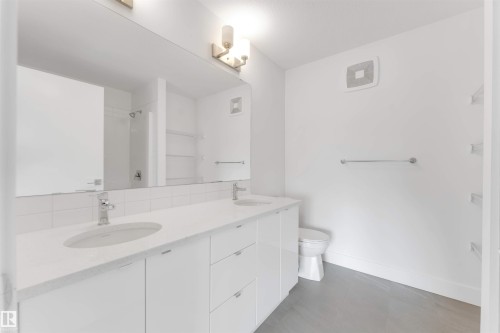This bathroom features a double vanity with two sinks and a spacious mirror - 1663 Cavanagh Boulevard Sw, Edmonton, AB - Indoor Photo Showing Bathroom