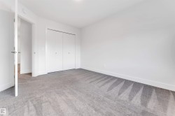 This room features neutral-toned carpet flooring, white walls, and a closet with bifold doors - 