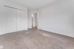 This room features light gray carpeting, white walls, and white bi-fold closet doors - 