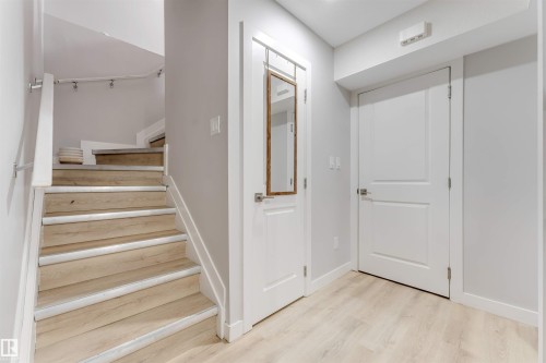 The property features light wood flooring and a staircase with light wood treads and risers - 1663 Cavanagh Boulevard Sw, Edmonton, AB - Indoor Photo Showing Other Room