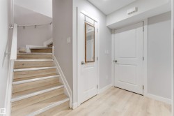 The property features light wood flooring and a staircase with light wood treads and risers - 