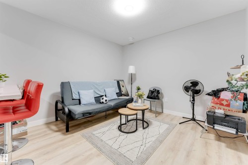 This living area features light-colored flooring and light grey walls, creating a bright and airy atmosphere - 1663 Cavanagh Boulevard Sw, Edmonton, AB - Indoor Photo Showing Living Room